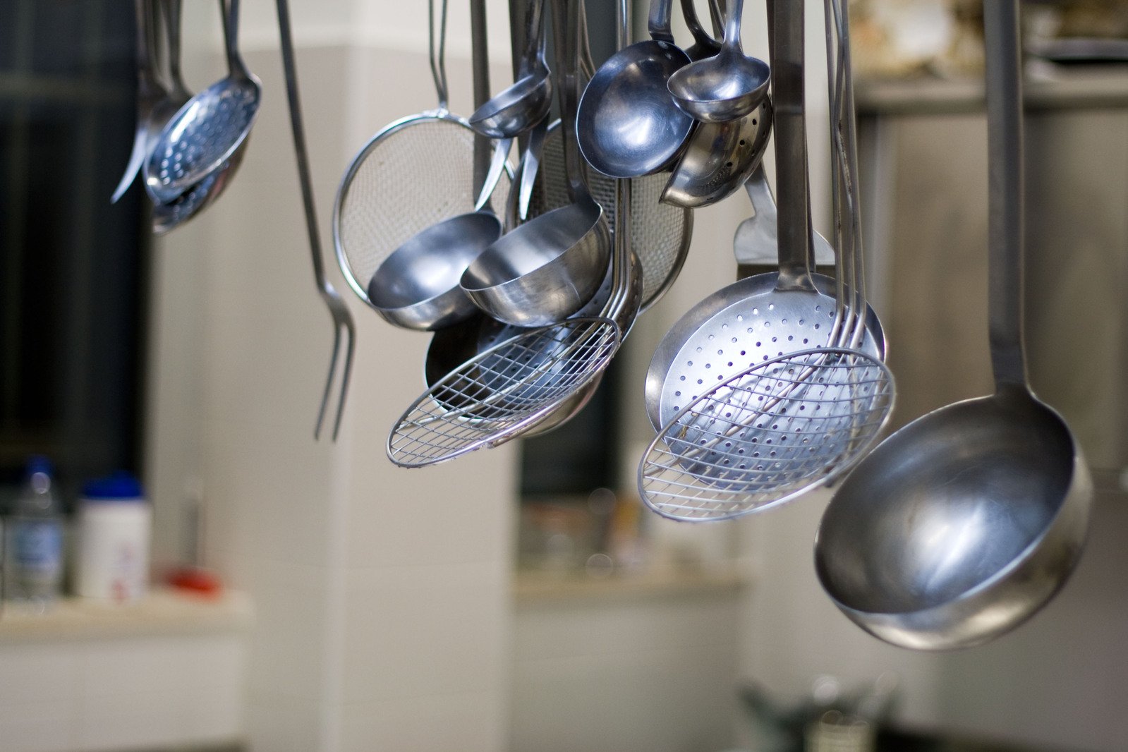 an assortment of pans hanging from a kitchen rack