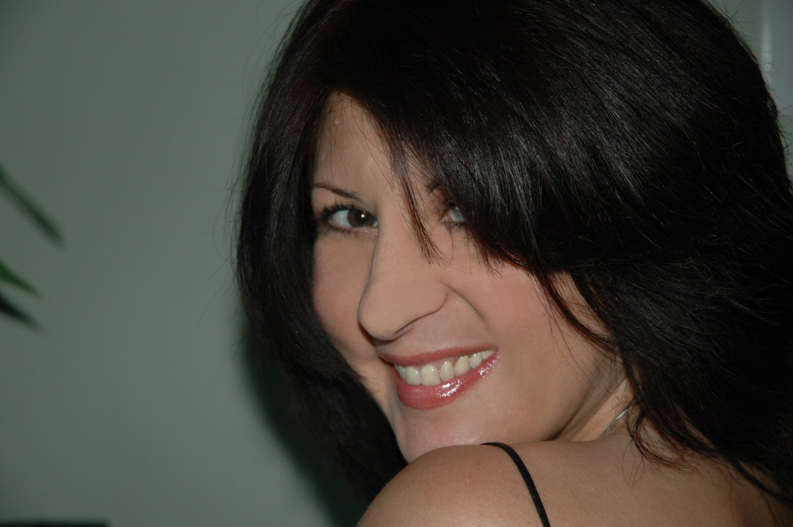 a woman smiling with a white teeth and black hair