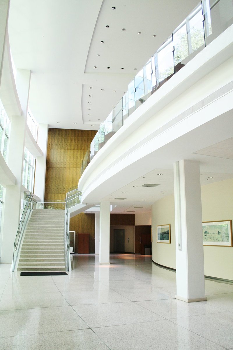 an empty lobby is seen with stairs and windows