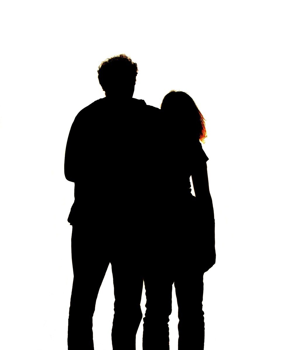 couple standing next to each other in silhouette