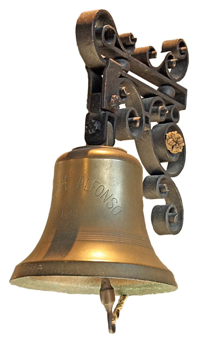 a gold and black metal bell hanging from a wall
