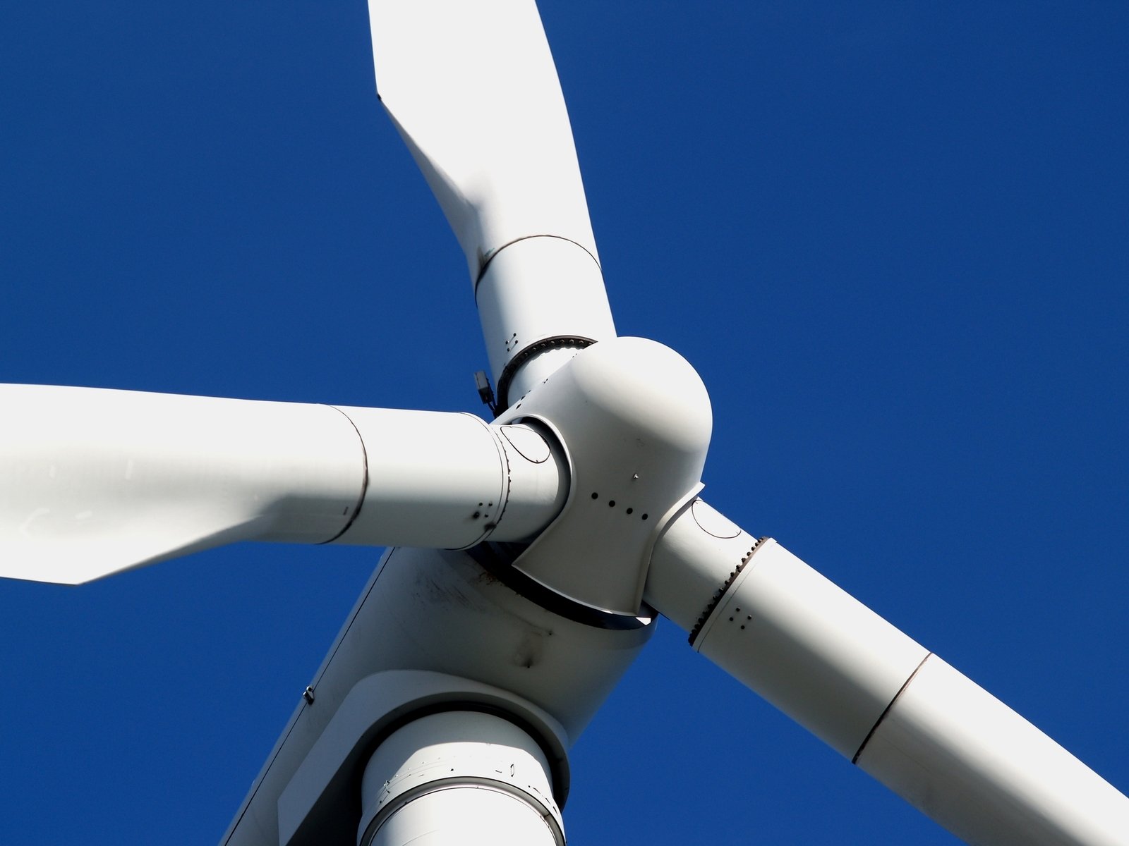 the view from below of a turbine at blue sky