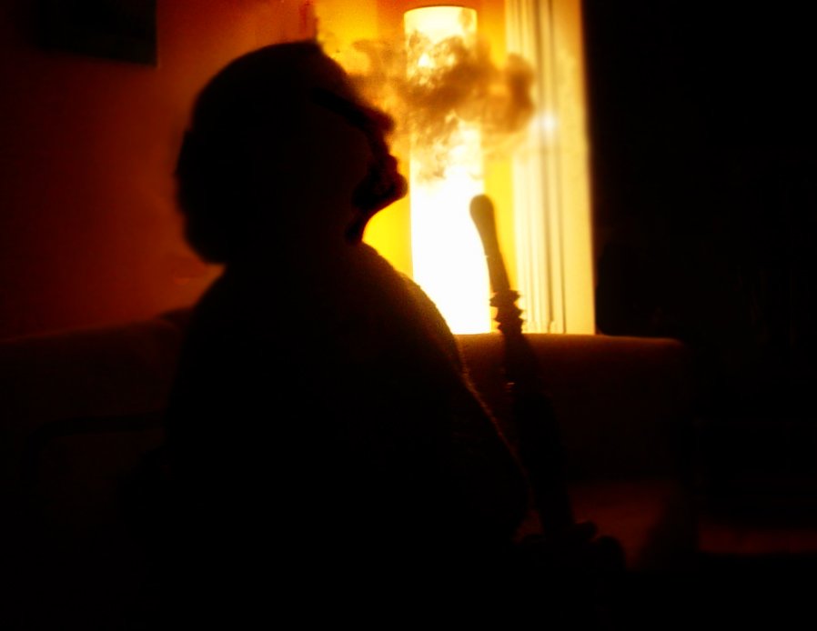 a person sitting in a dark room and holding a bat