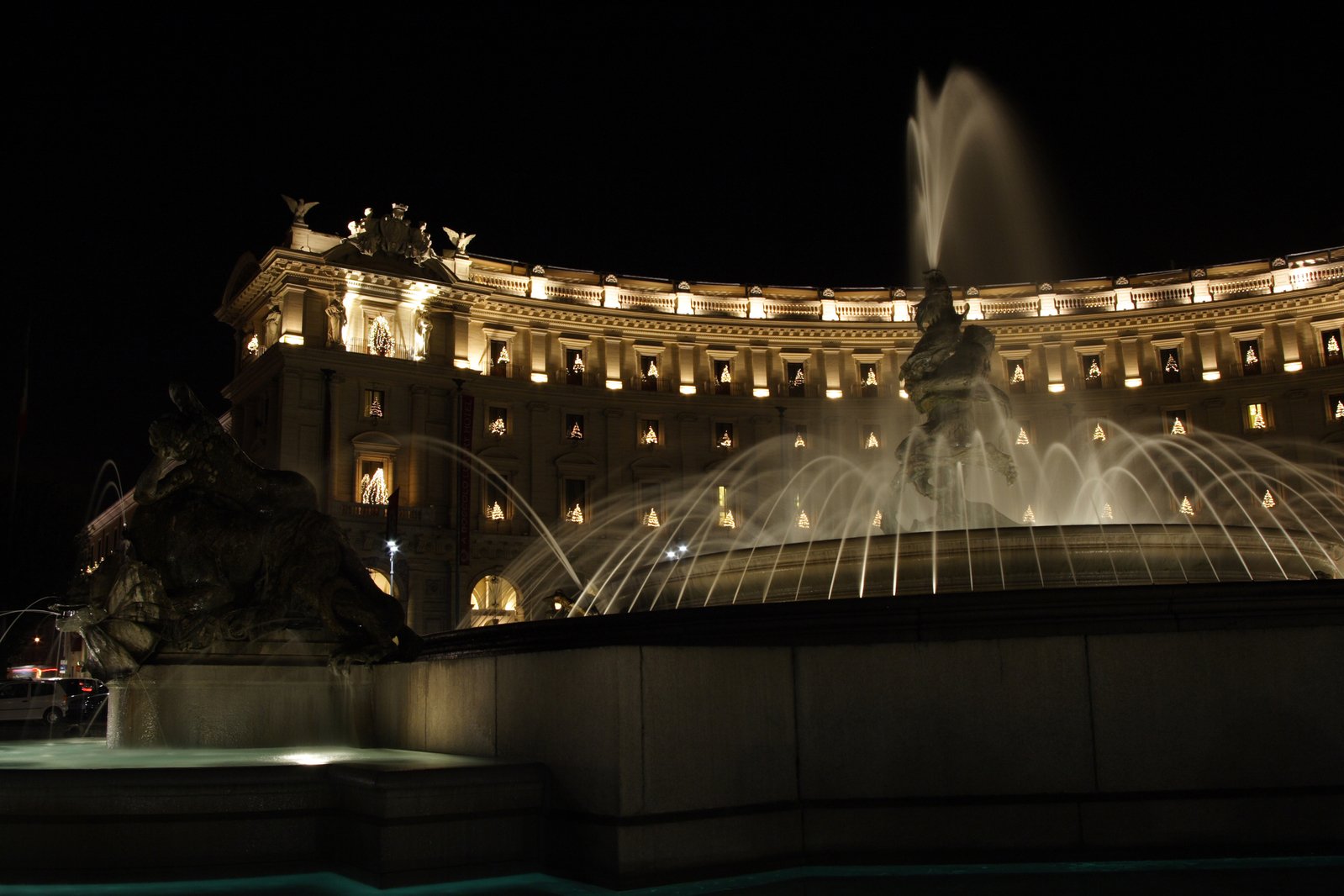 the fountain in front of the building has many lights on it