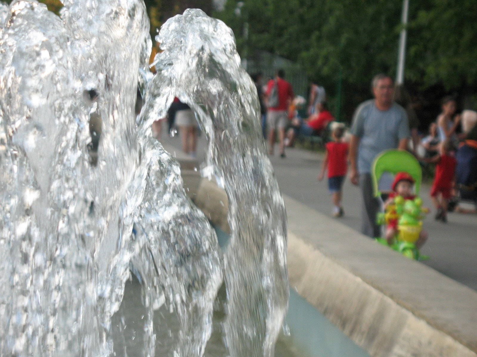 a man is standing near a water fountain in front of people