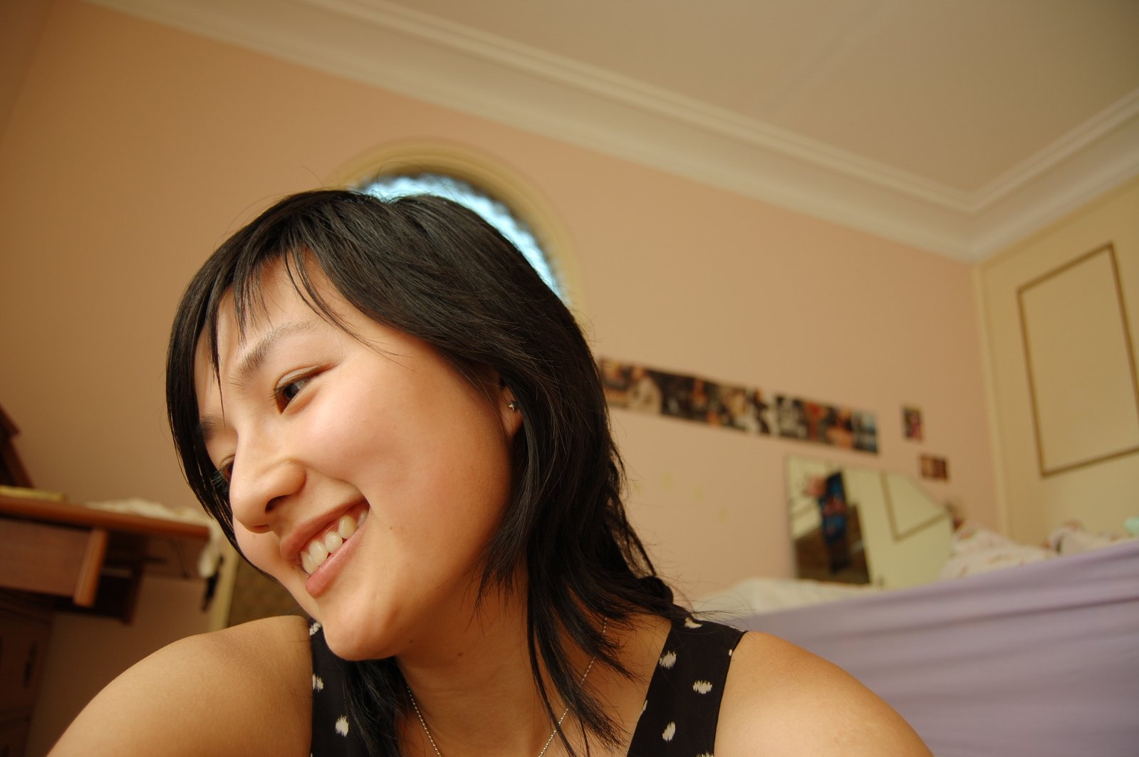 a woman with bangs smiling and laughing at the camera