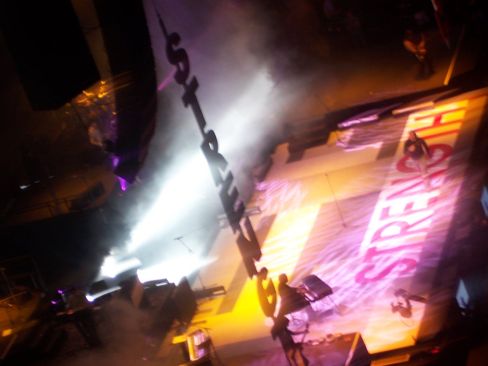 bright stage lights shine from above a crowd