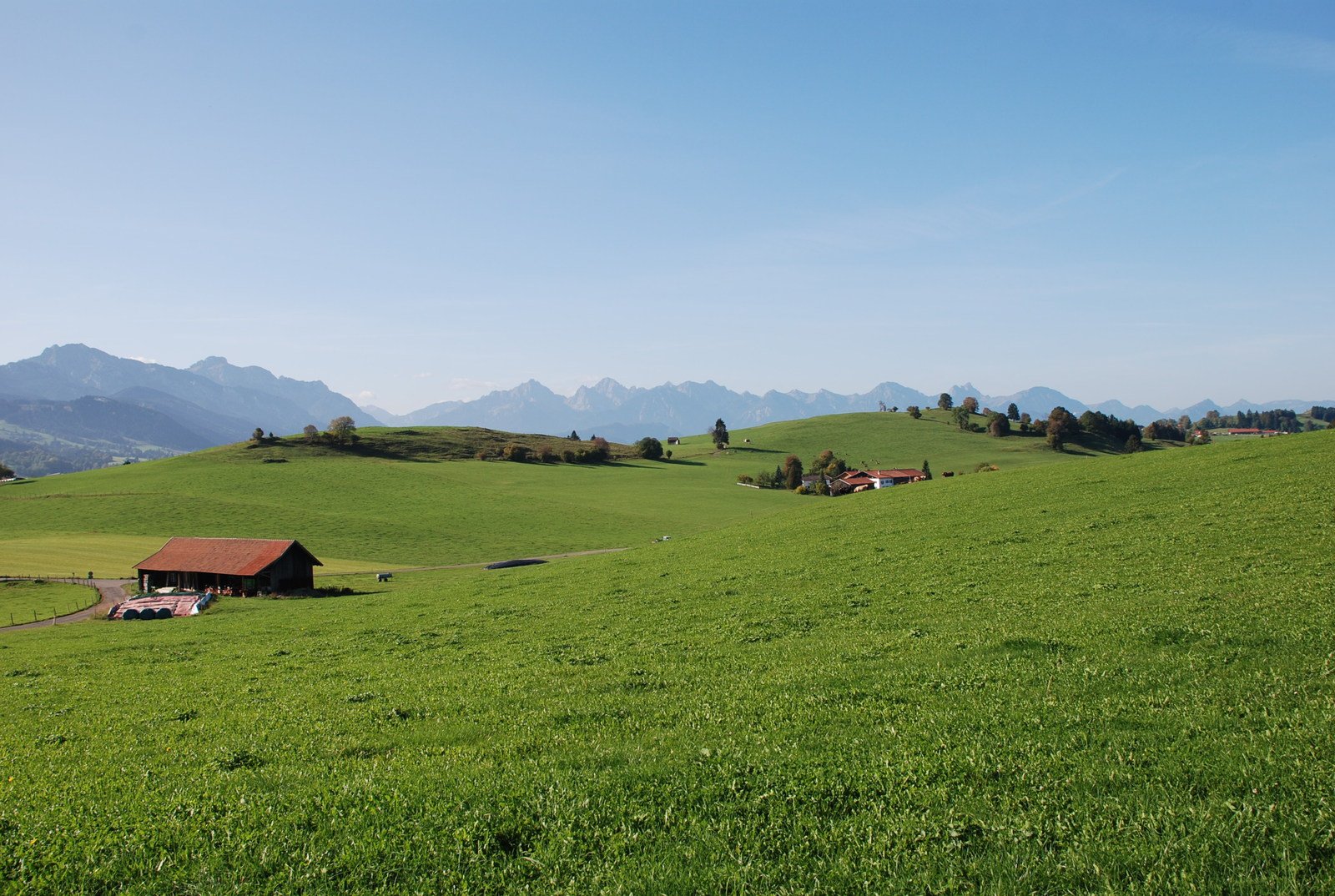 two small cottages on a green field in the mountains