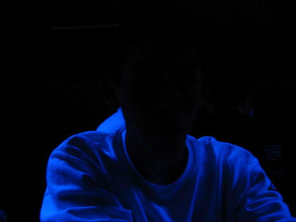 a man in blue glow sitting at the counter