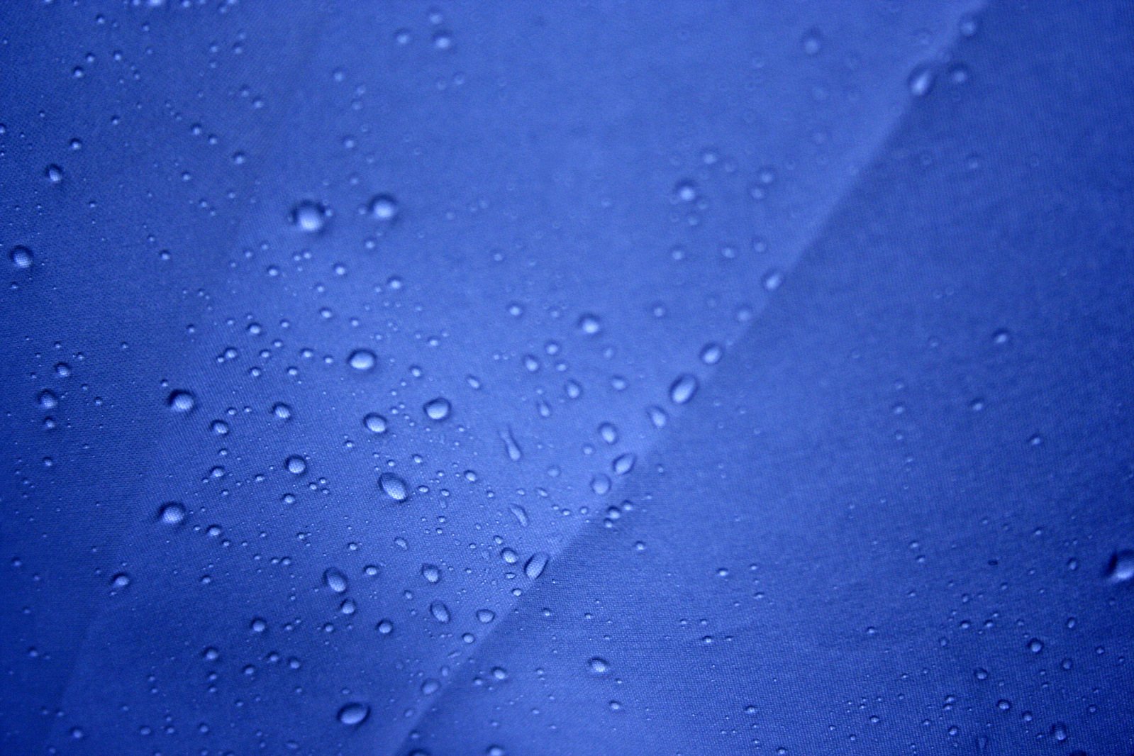 drops of water on a shiny surface with a blue color