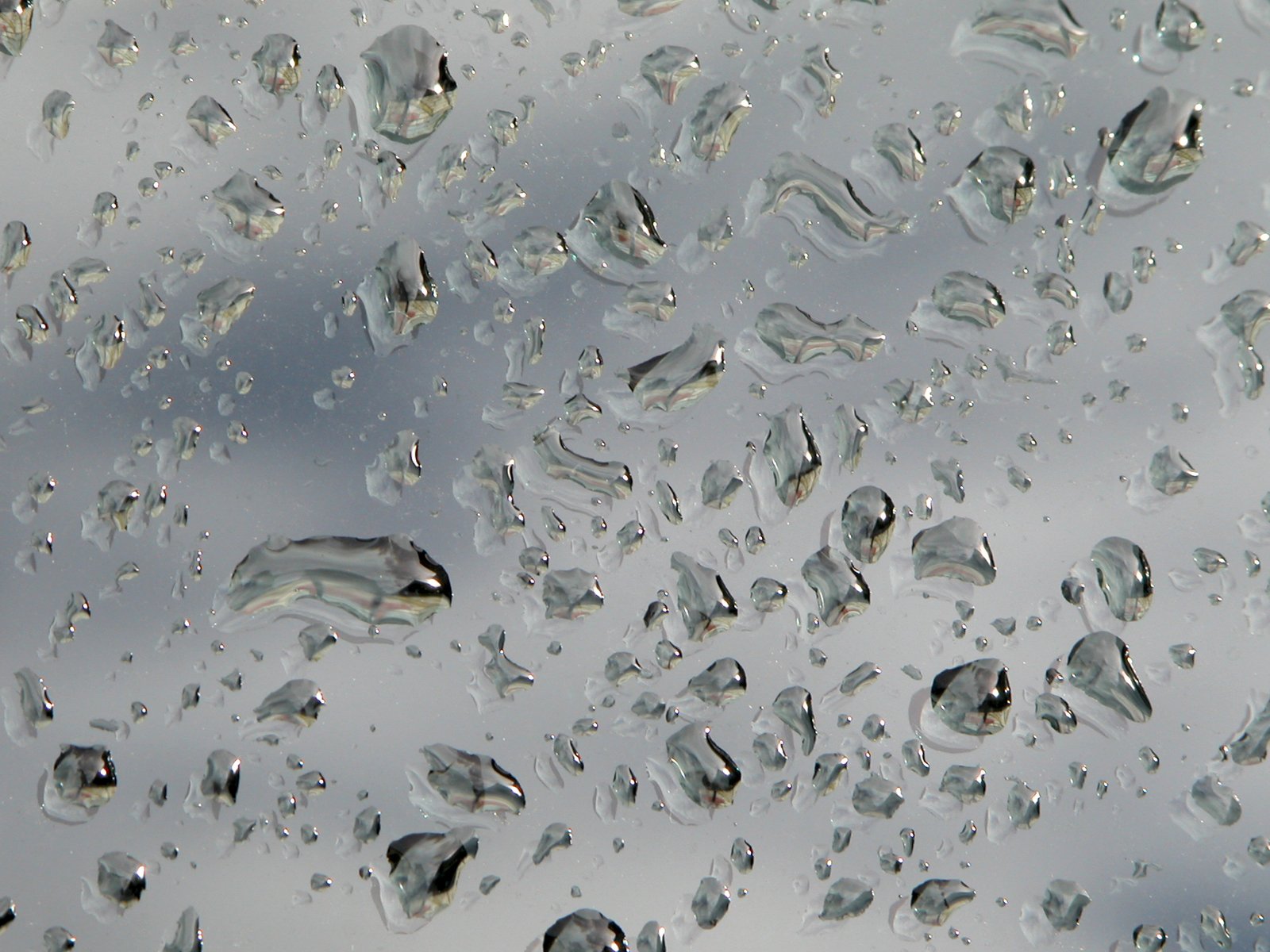 rain droplets on the window and a blue sky in the background