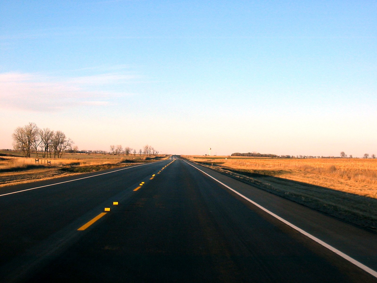 a highway surrounded by an empty field and some dry grass