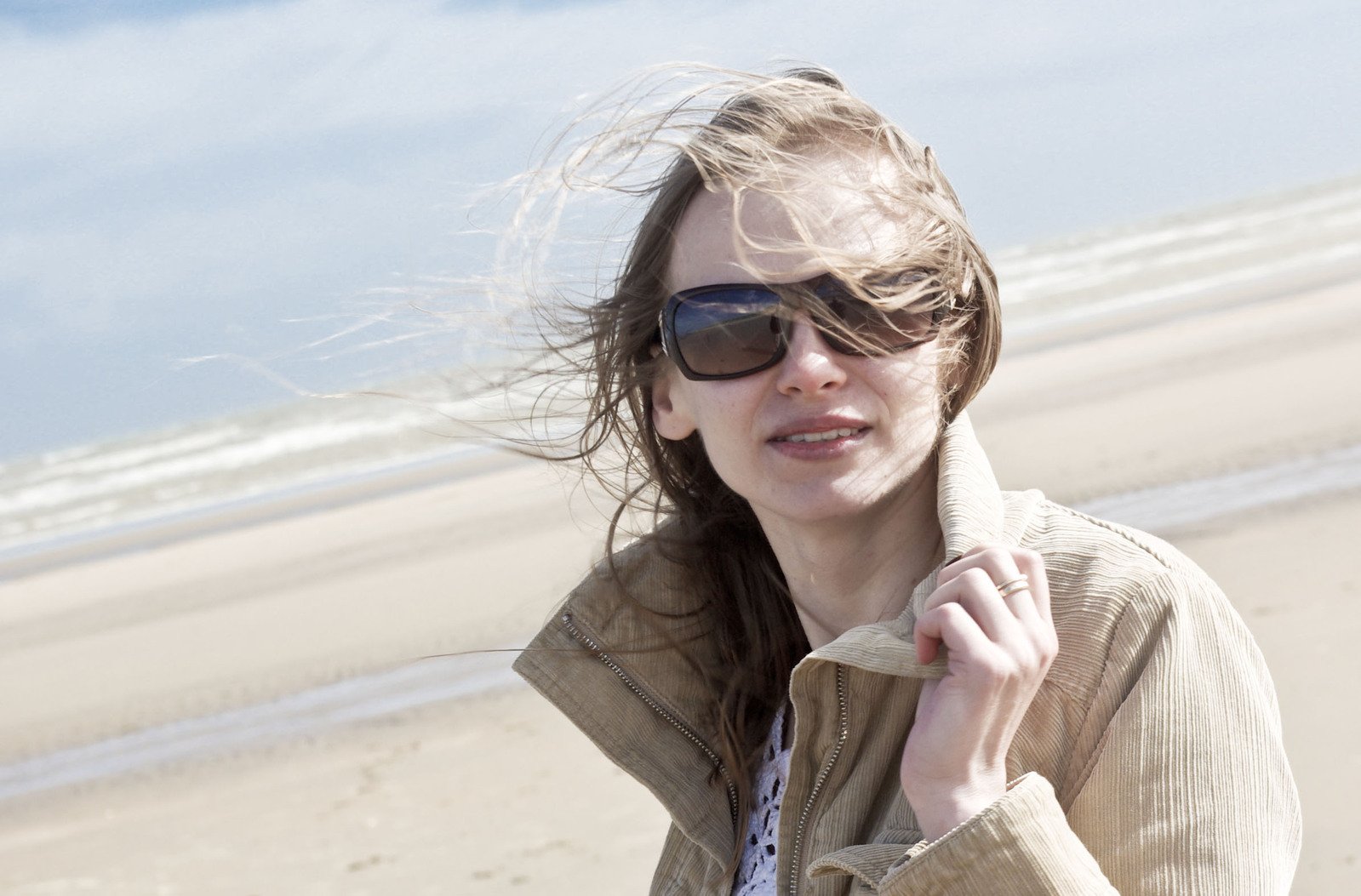 woman on beach with wind blowing hair behind her