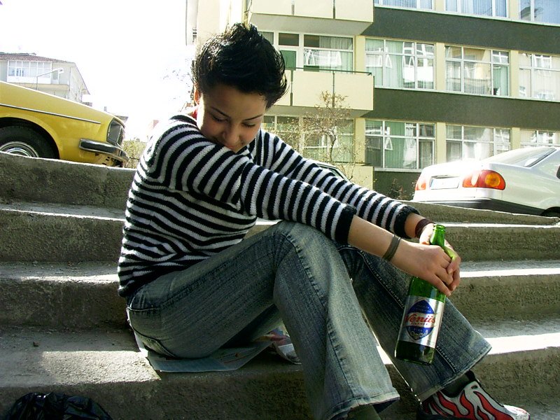 a young man sits on the steps with his foot up