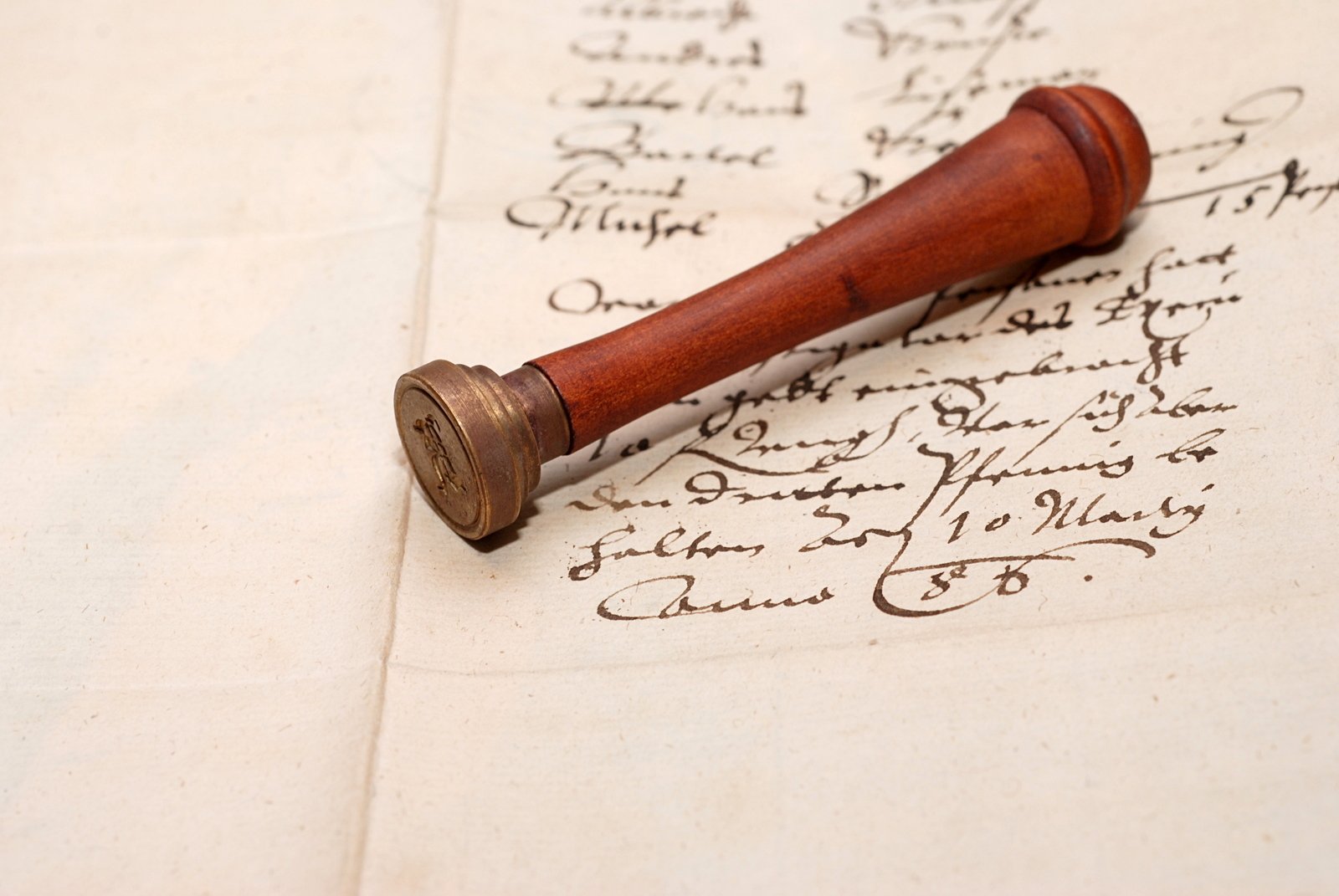 a wooden fountain pen is resting on top of an old letter