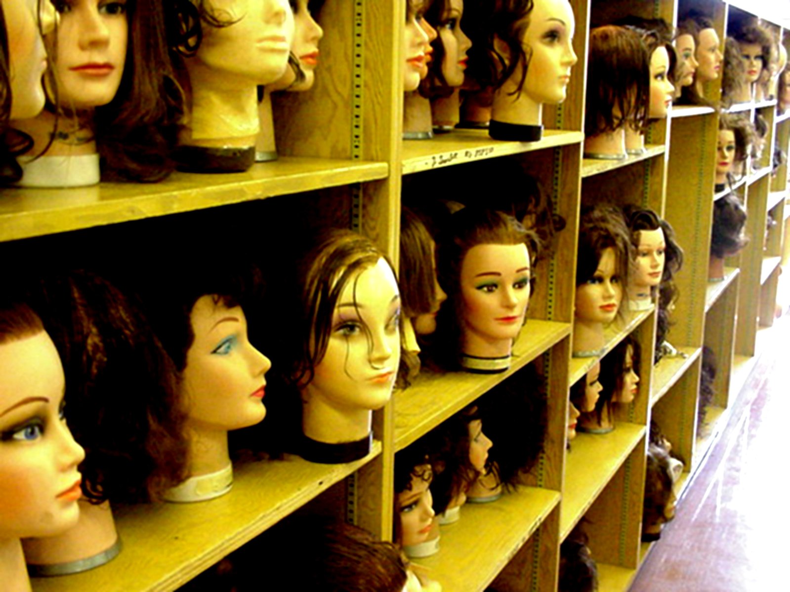 a shelf filled with lots of wigs of different sizes