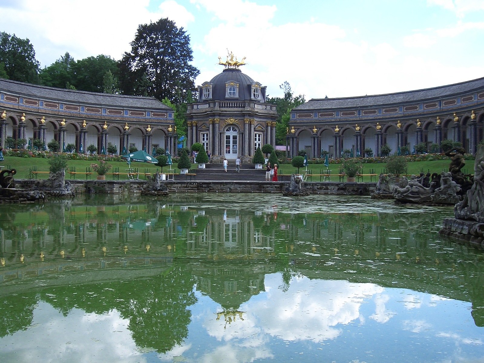 a pond in front of a large building and some water