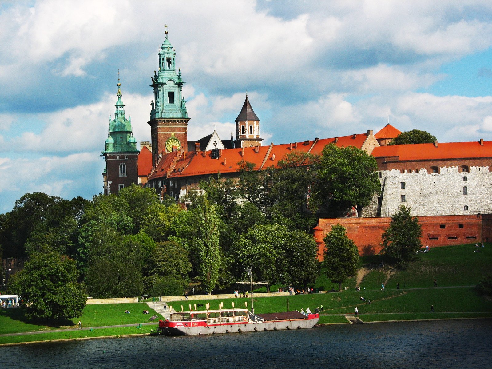 a river cruise boat on a scenic lake and old buildings