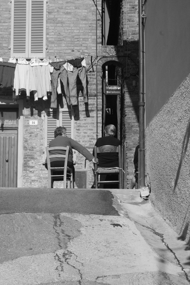 the person sitting in a chair has laundry hanging from a clothes line