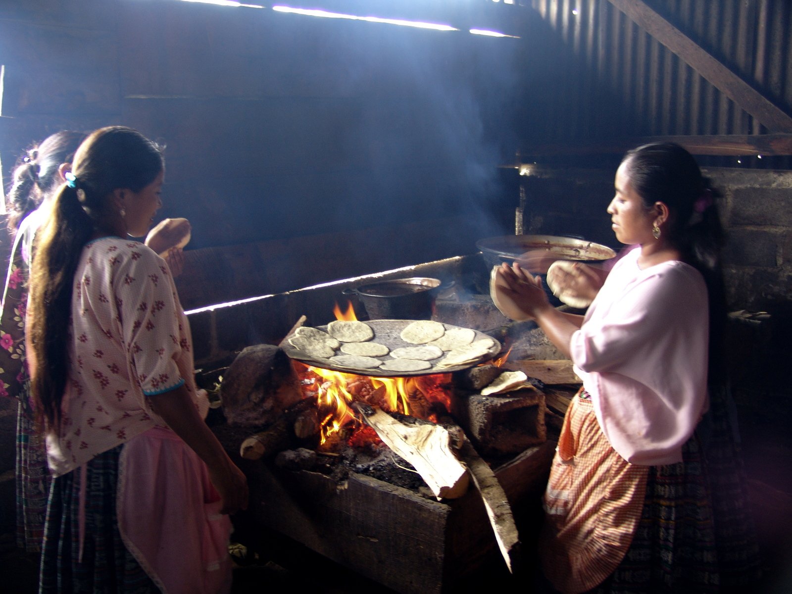 two s making food on an open fire