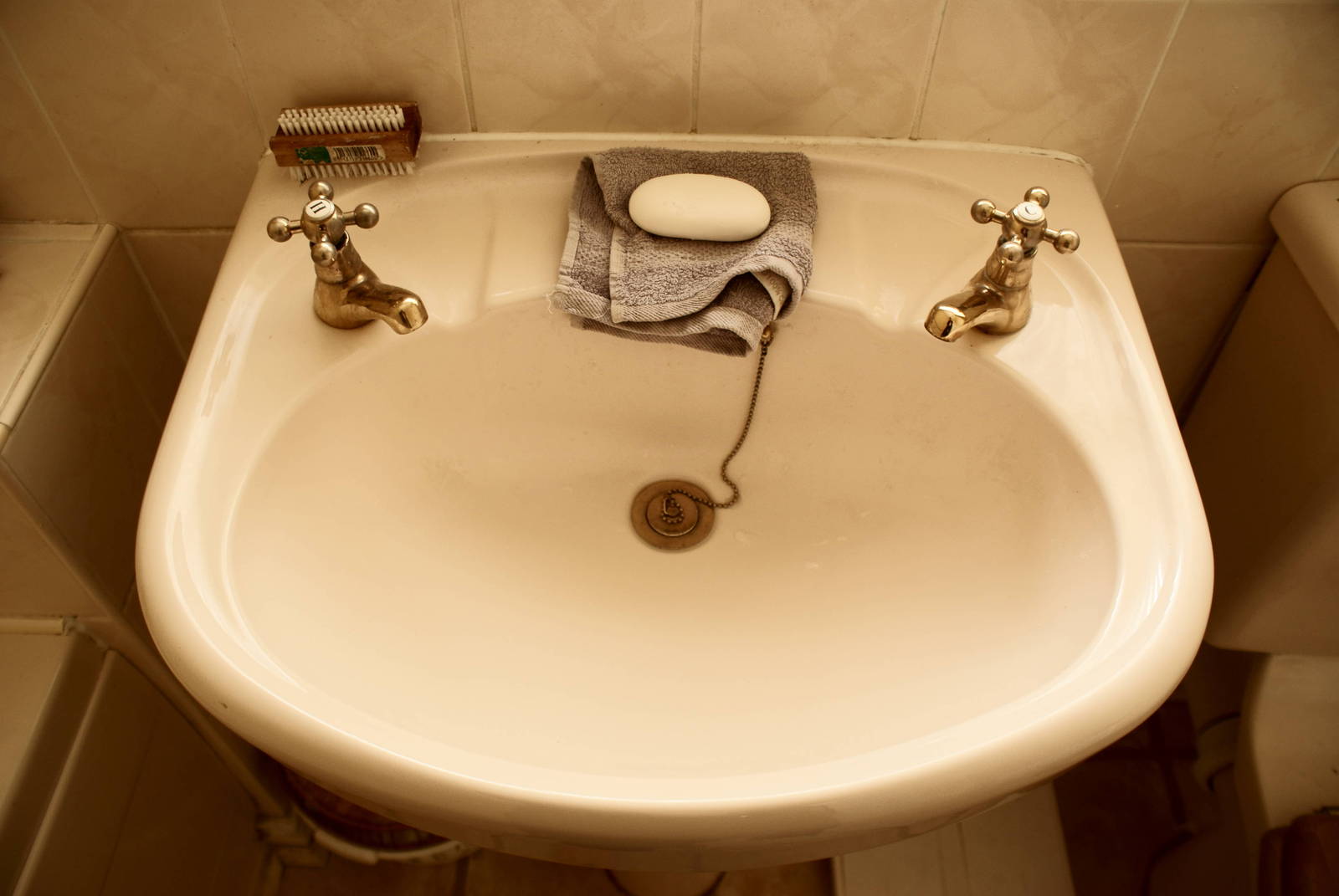 a white sink with a towel and brush on it
