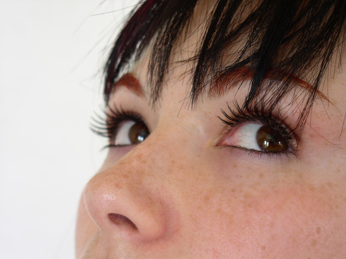 a woman with brown eye lashes looking at the camera