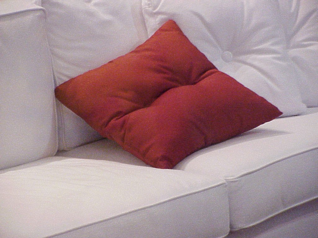 a couch with two orange and white pillows