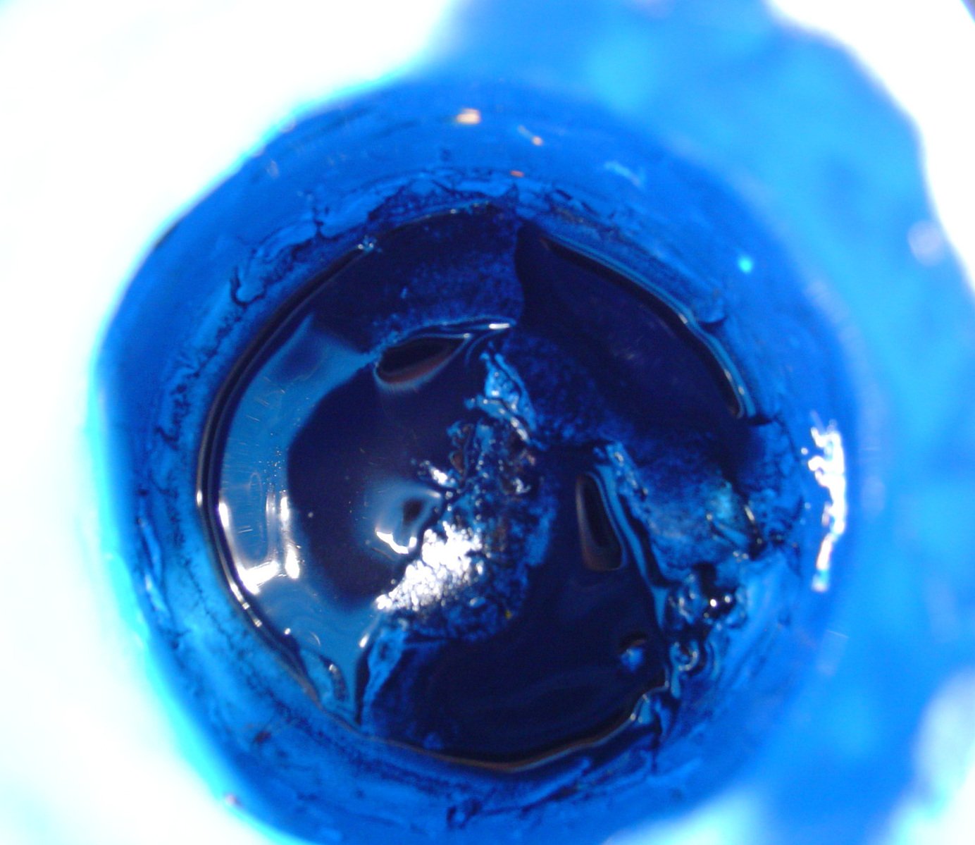 the top of a blue bottle showing its black inside