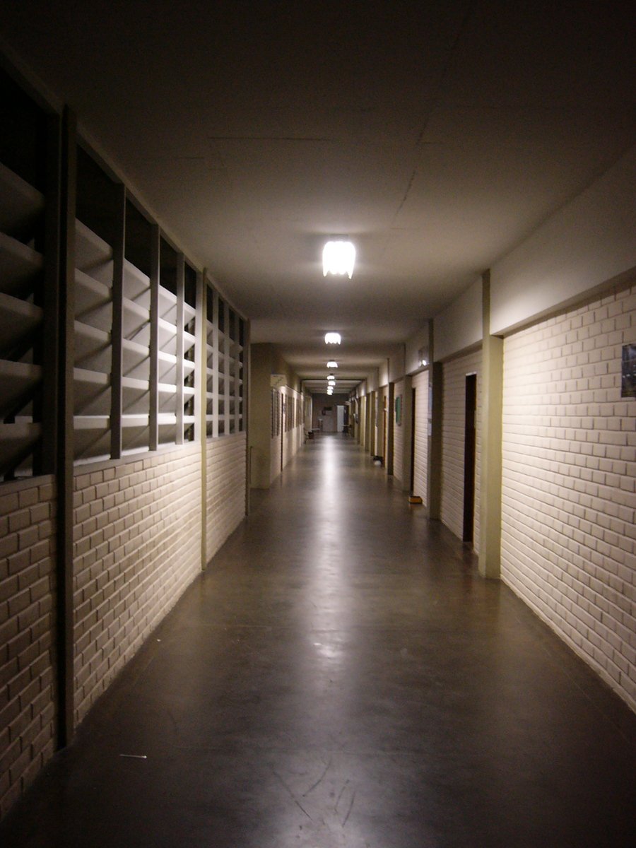 an empty long dark hallway in a building