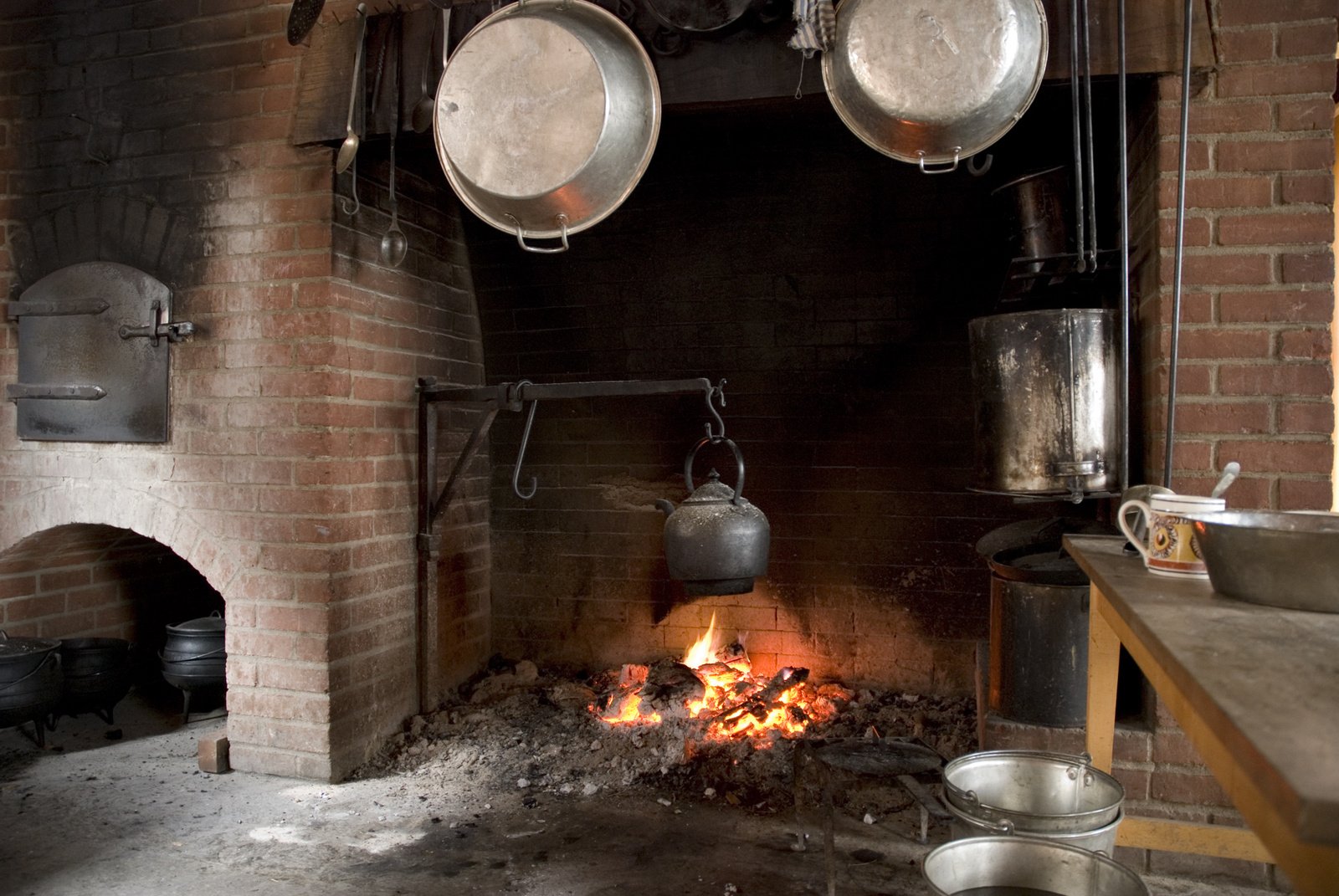 several pots on racks hanging above the fire place