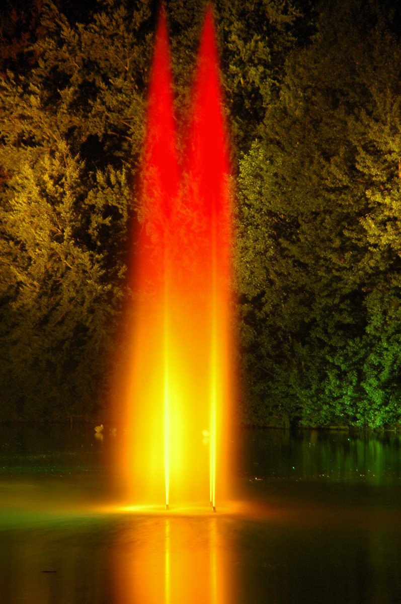 a fountain in the middle of some water at night