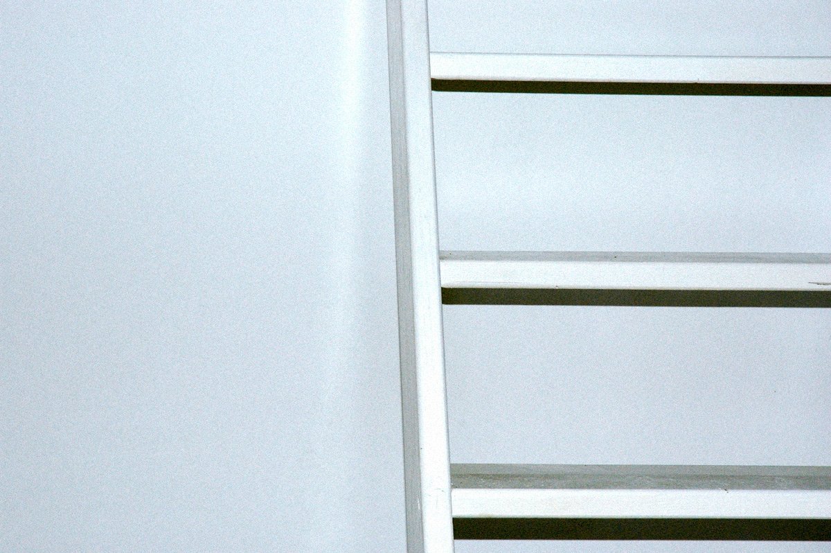 a white shelf with no drawers sits against a wall