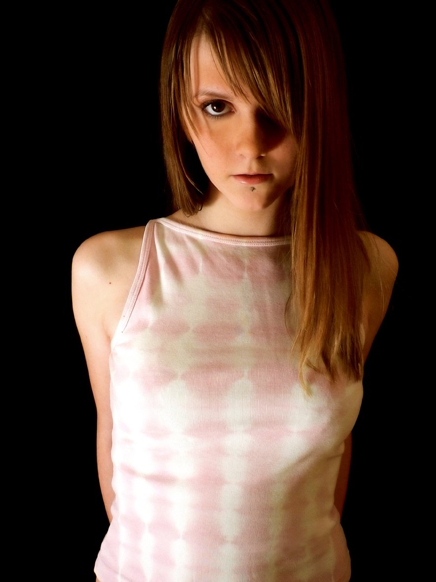 a woman in pink shirt posing with a black background