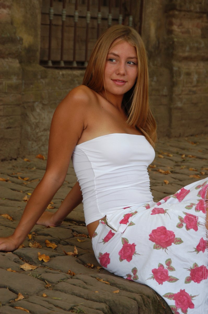 young woman sitting on the ground in white clothing
