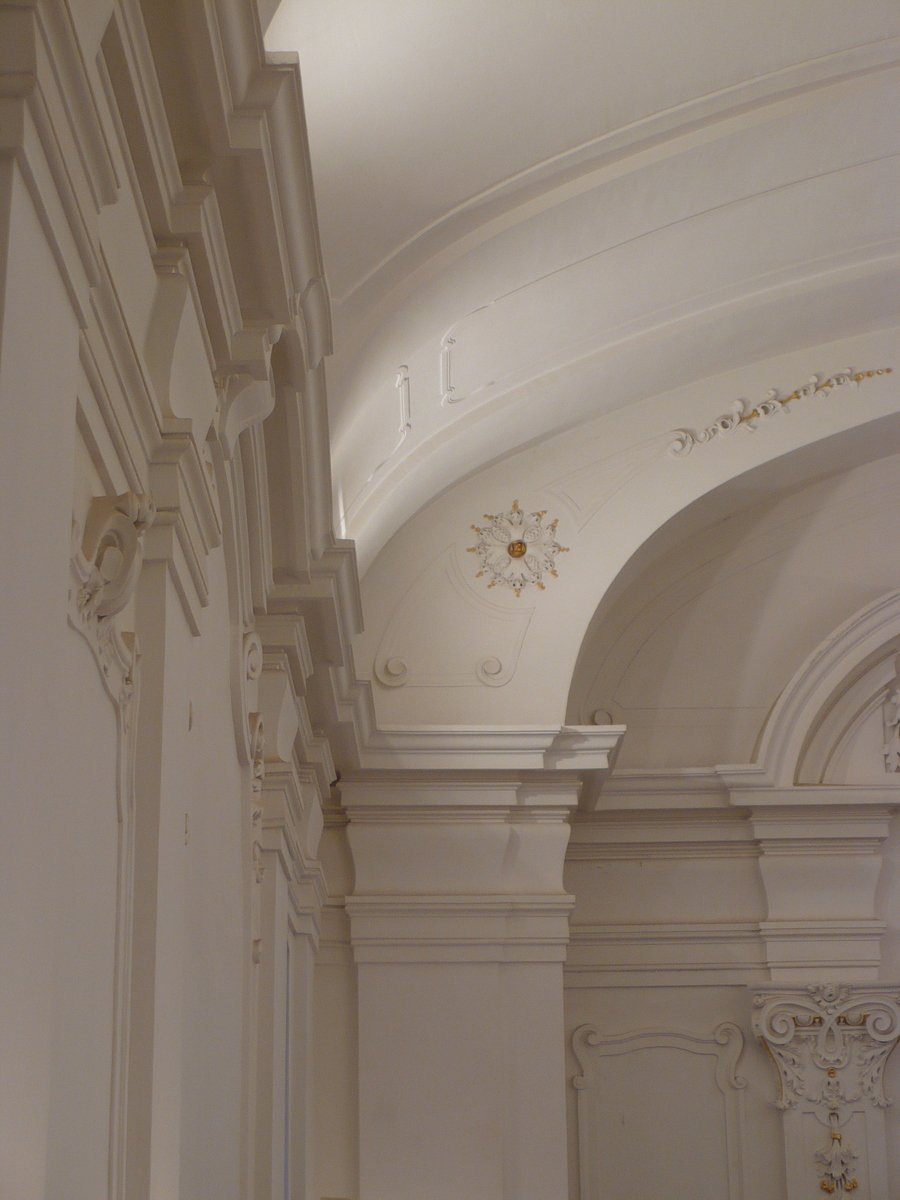 a large white room with arches and moldings
