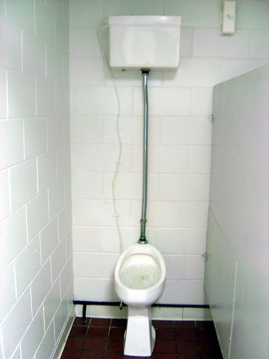 an electrical device hanging over the top of a toilet