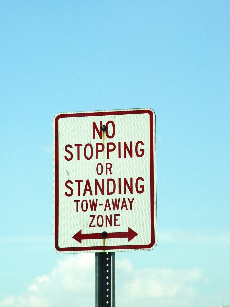 a street sign that has red arrows on it