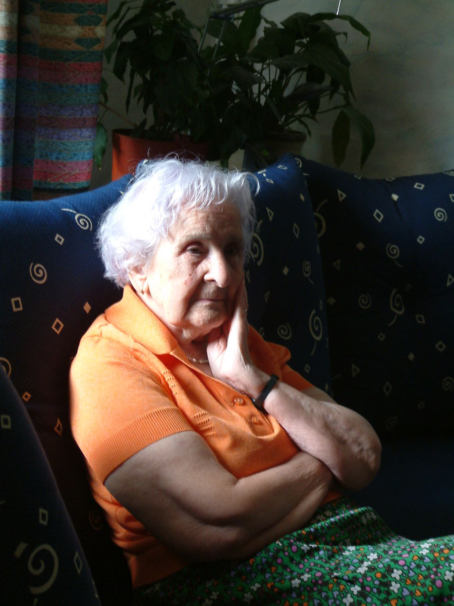 an older woman sitting on top of a blue couch