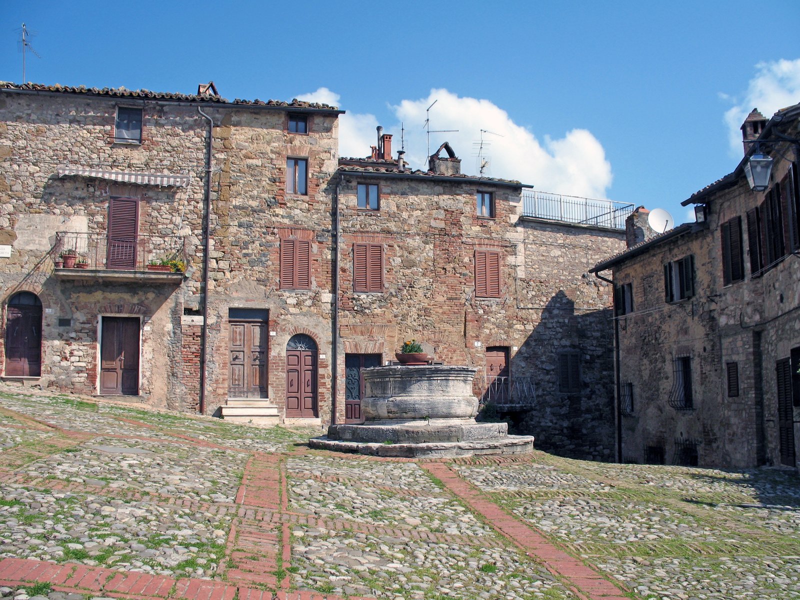 a stone street lined with buildings in the daytime