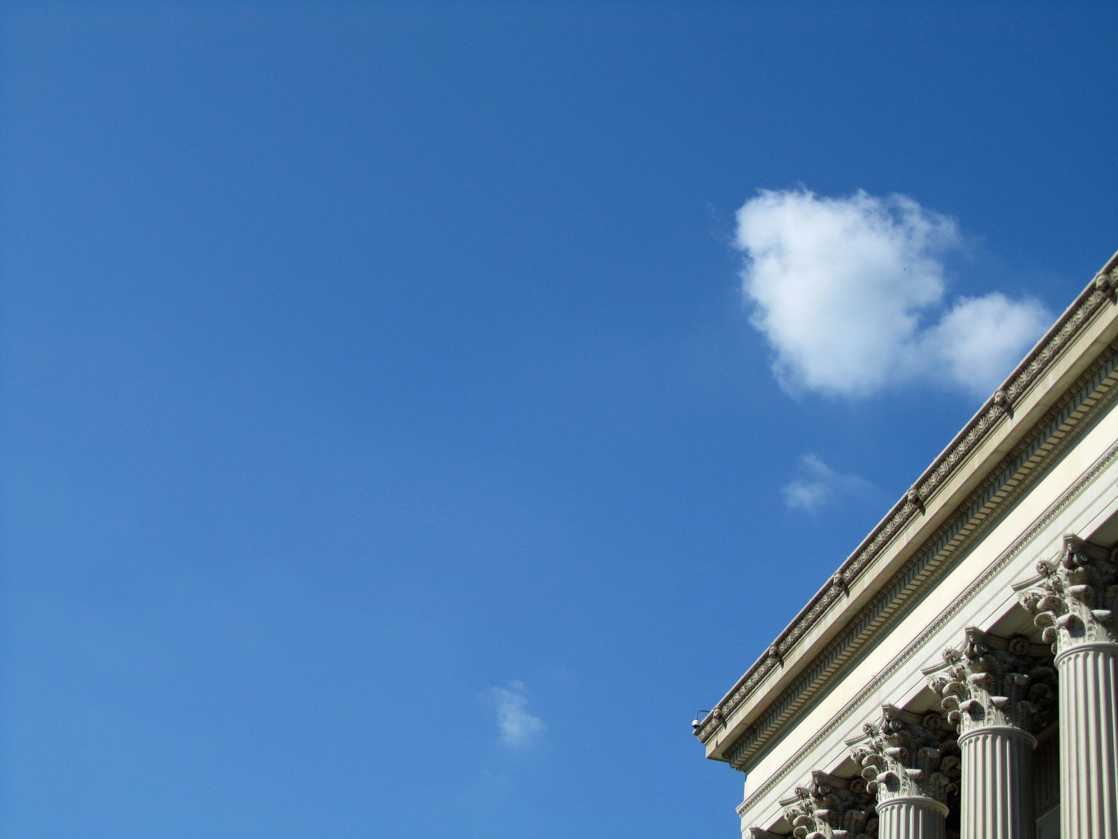 a lone plane is flying above a large building