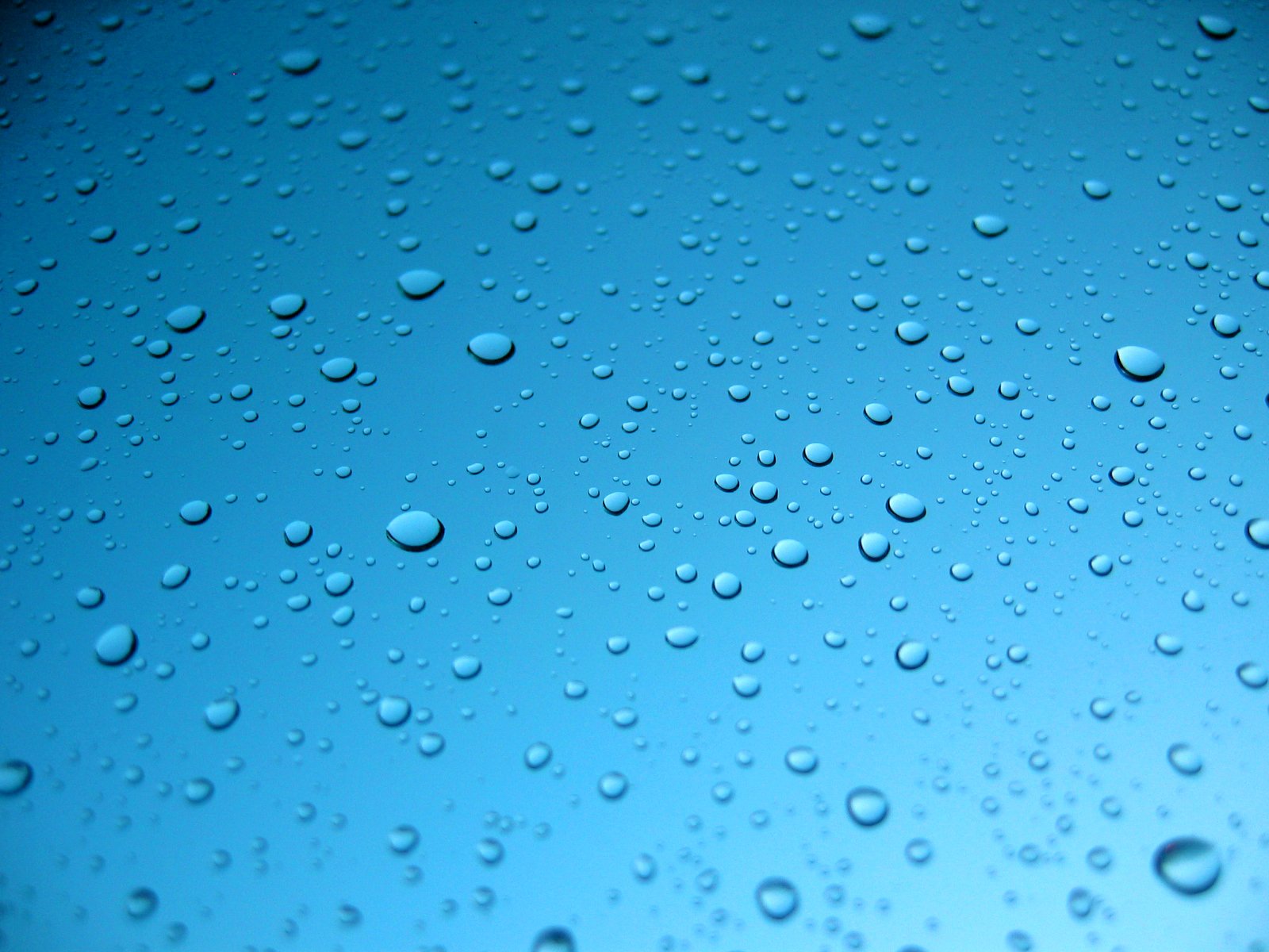 some water drops on a window as it sits in the dark