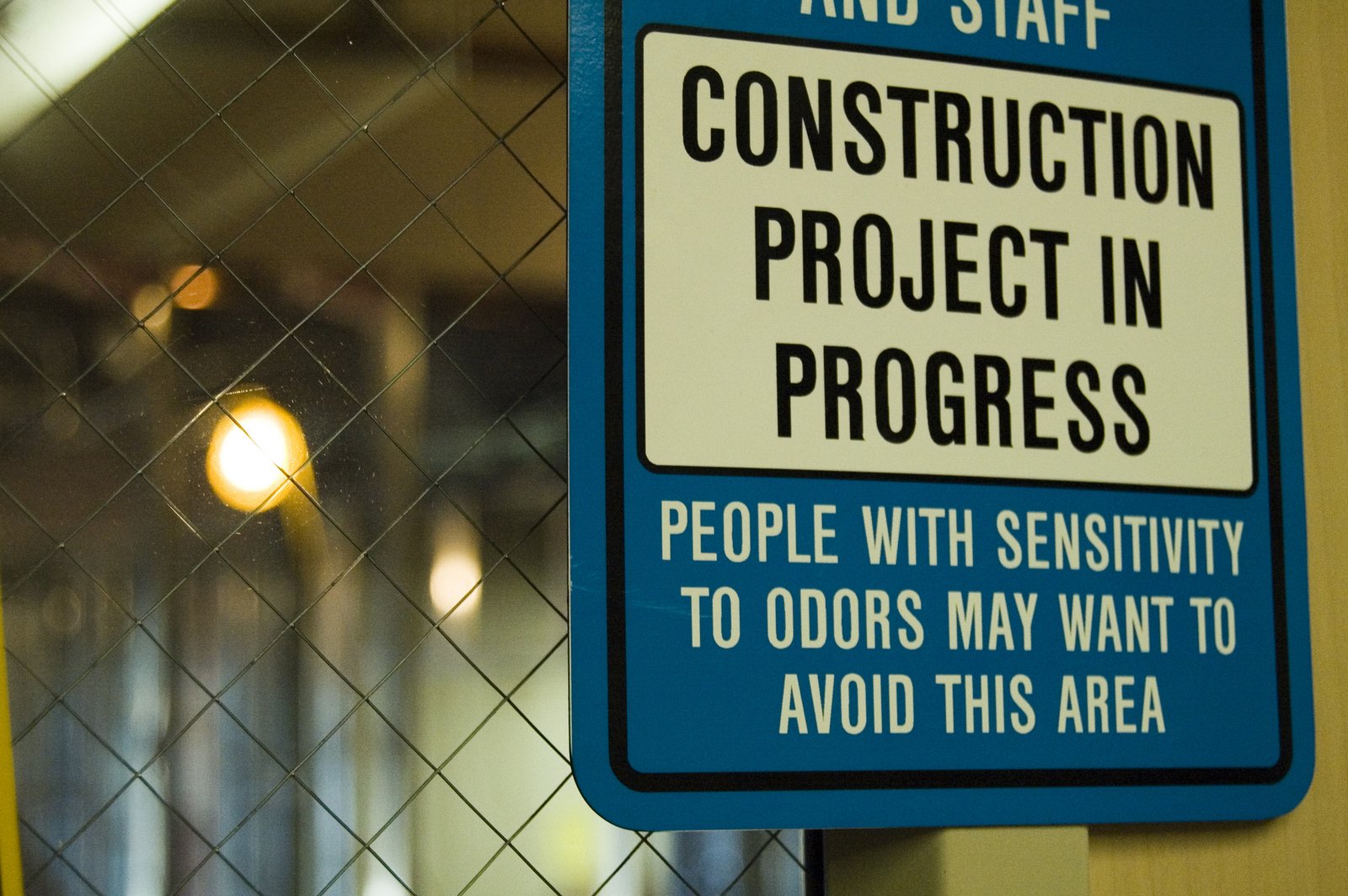 a blue sign attached to a chain link fence