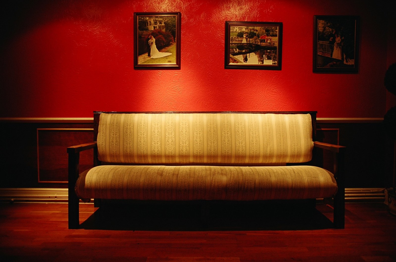 an empty couch sits in a red room