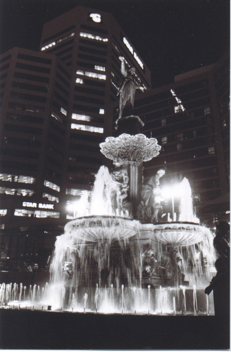 a fountain with lots of water lit up by people