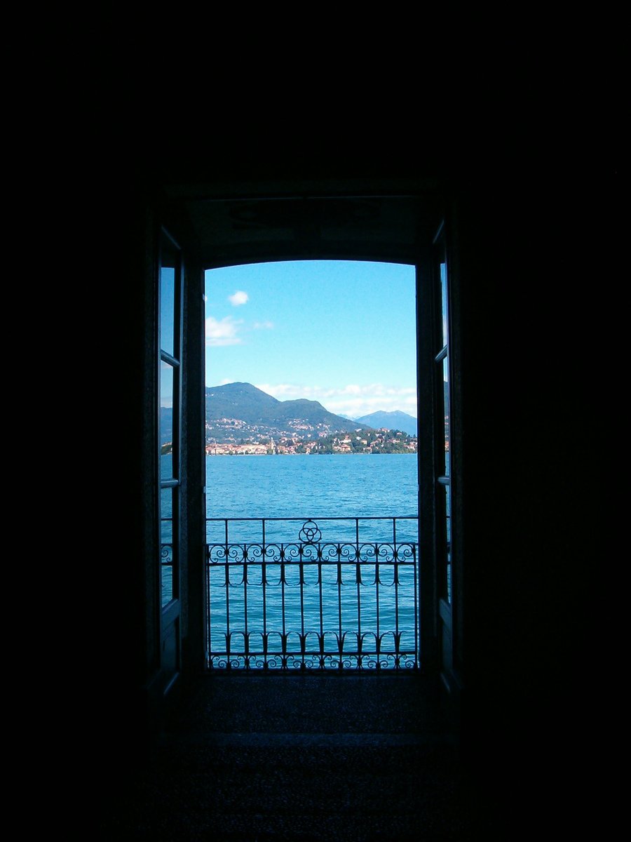 an open door with the ocean and mountains in the distance