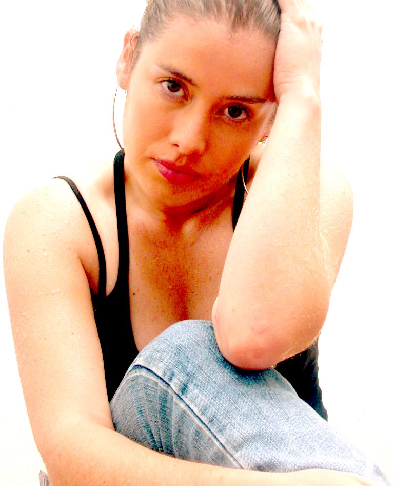 a woman is sitting down holding her hair up