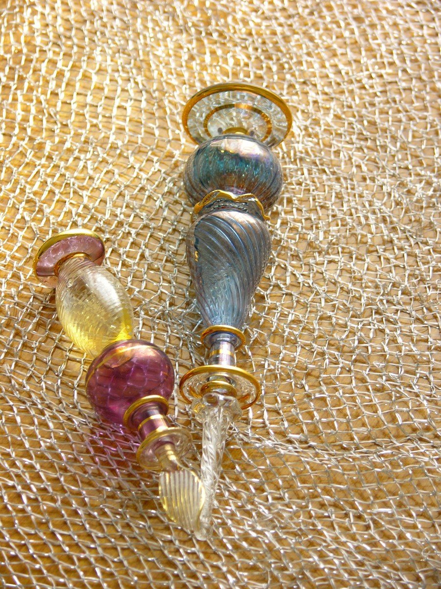 three glass items sit on top of a beige cloth