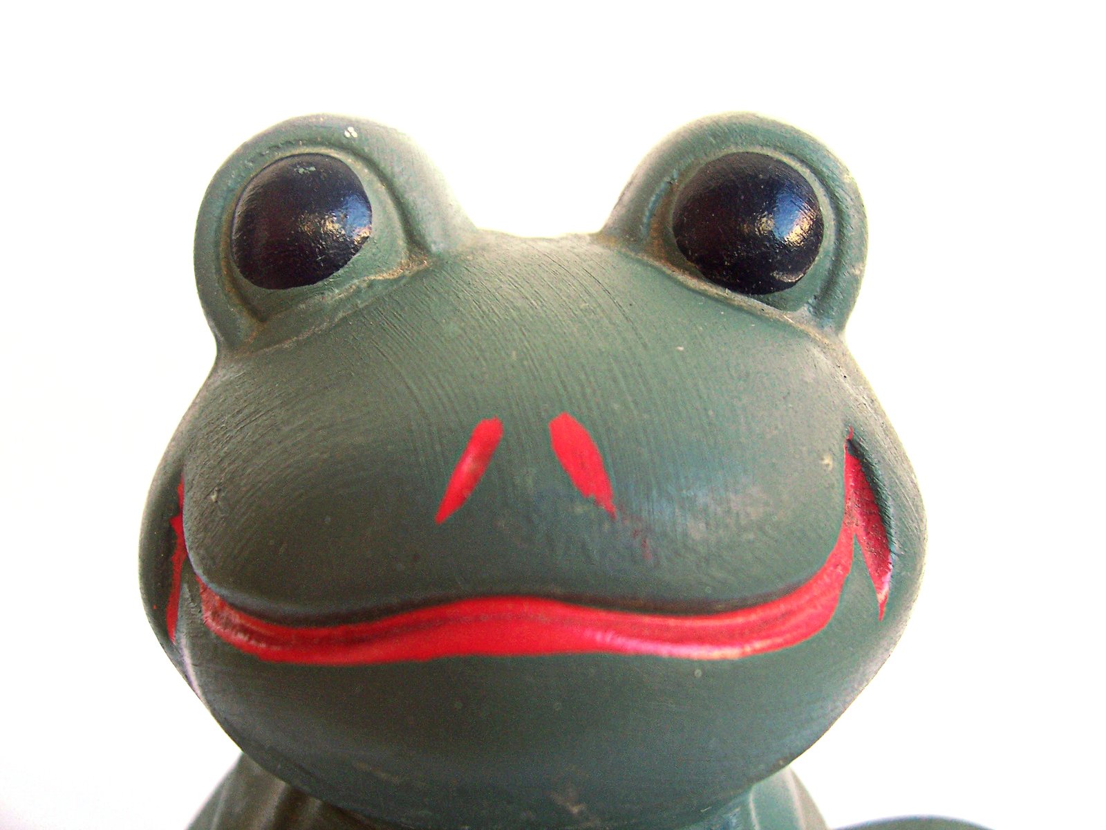 a red - eyeed frog toy is shown with a background