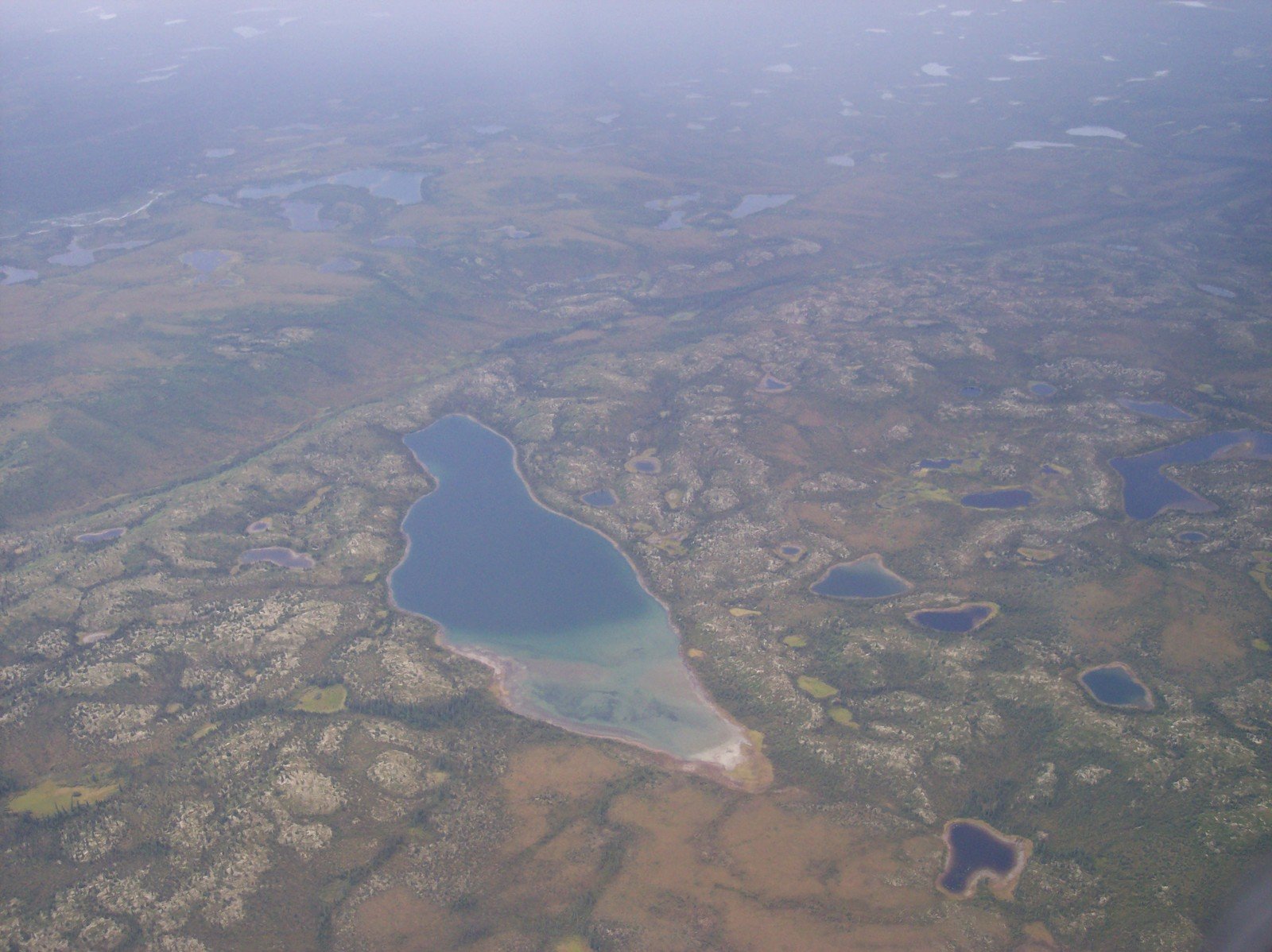 an airplane flies over the vast landscape of the countryside