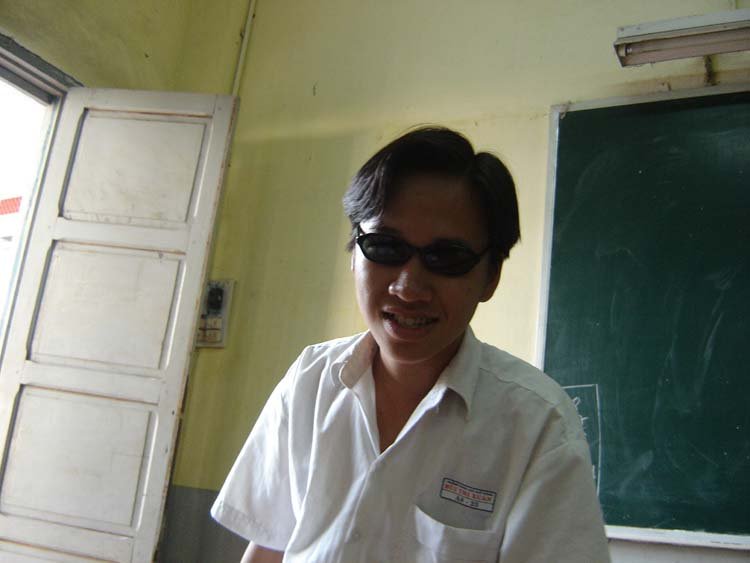a man standing by a blackboard wearing sunglasses